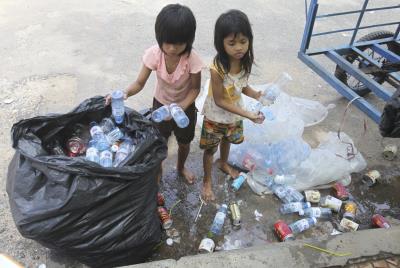 Unas niñas camboyanas recogen latas y botellas de plástico en una calle de Phnom Penh, en una foto de 2011.