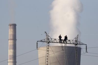 Empleados trabajando sobre el humo de una fábrica en la ciudad de Obilic, Kosovo.