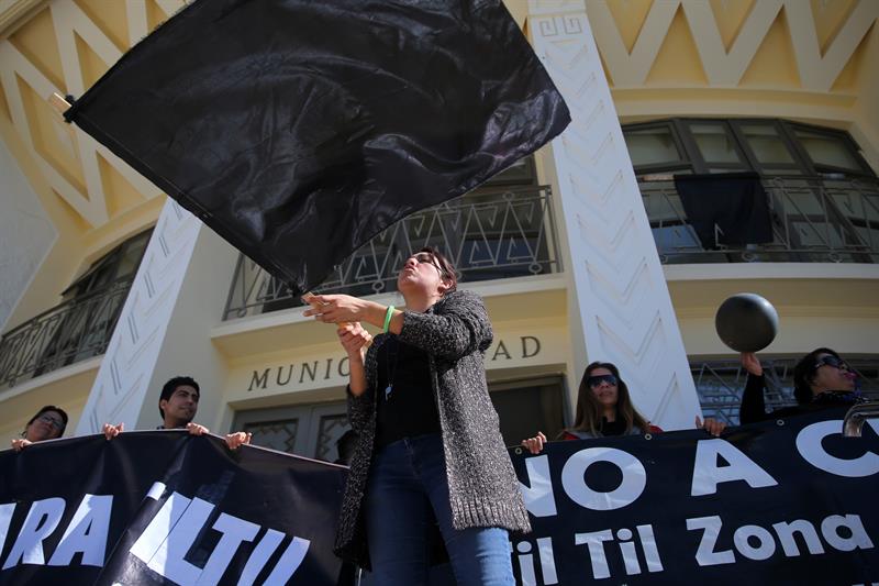Una mujer ondea una bandera negra durante una manifestación en Til Til.