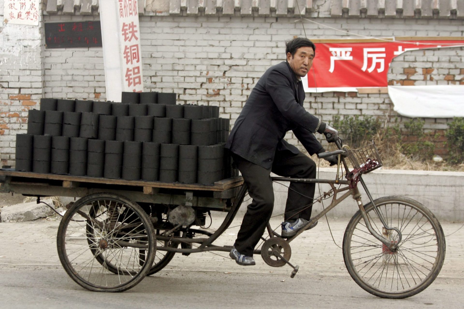 Un chino transporta briquetas de carbón en Pekín.