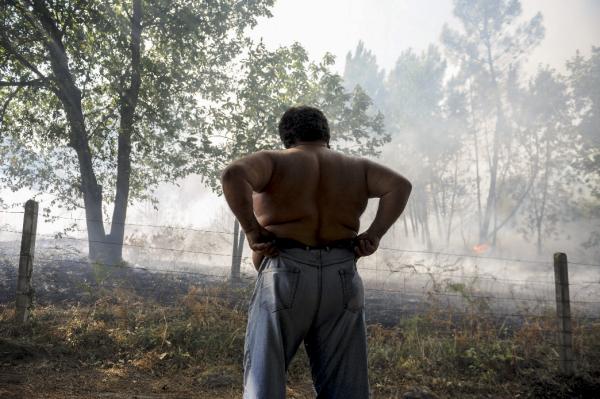 OURENSE, 29/08/2015.- Un hombre observa el incendio forestal originado en la parroquia de Cudeiro, a las afueras de Ourense, por el que la Xunta ha decidido adoptar medidas preventivas de nivel 2 de alerta, ante el riego de que el fuego pueda aproximarse a viviendas habitadas de la zona. EFE/Brais Lorenzo