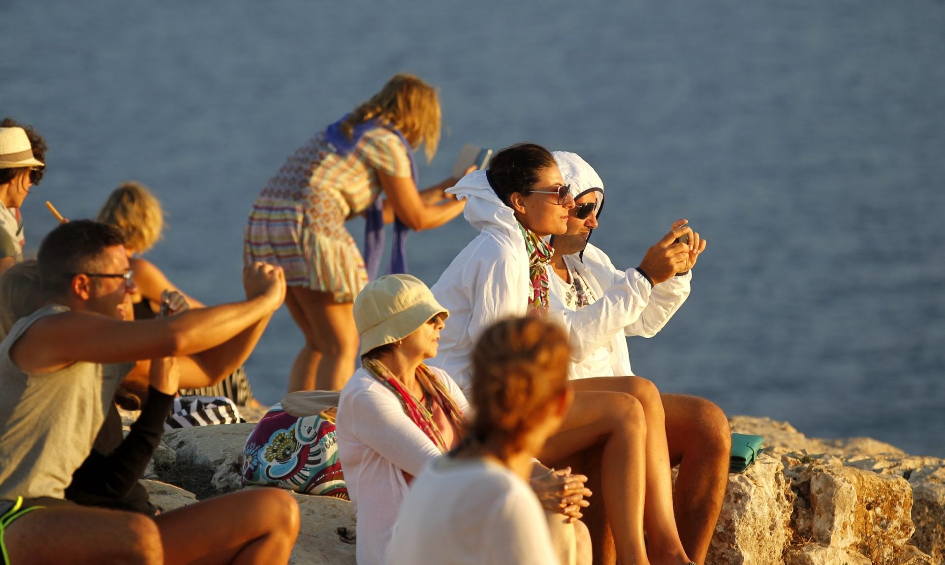 Turistas contemplan el atardecer en Formentera. Foto: JJ Guillén (EFE)
