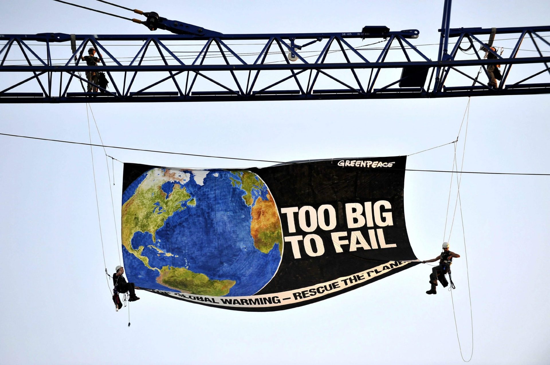 En 2009, en Washington, dos ecologistas de Greenpeace despliegan una pancarta de 55 metros cuadrados, colgados de una grúa para pedir medidas reales para salvar el planeta.