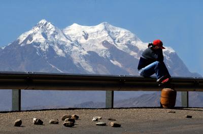 Una joven espera el camión de gas en la autopista que une la ciudad de La Paz con la de El Alto. 