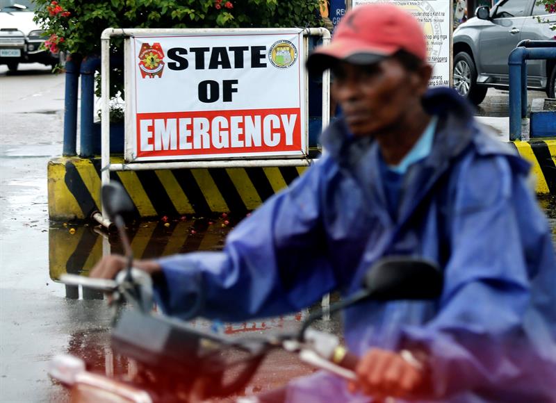 Un motorista pasa junto a una señal que alerta de la llegada del tifón Heima en la localidad de Lal-lu, provincia de Cagayan. 
