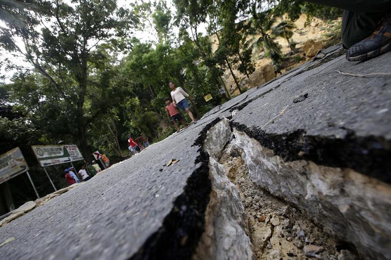 Varias personas caminan por una carretera destruida tras el terremoto de 7,2 grados de magnitud en Loon (Filipinas) hoy, miércoles 16 de octubre de 2013. 