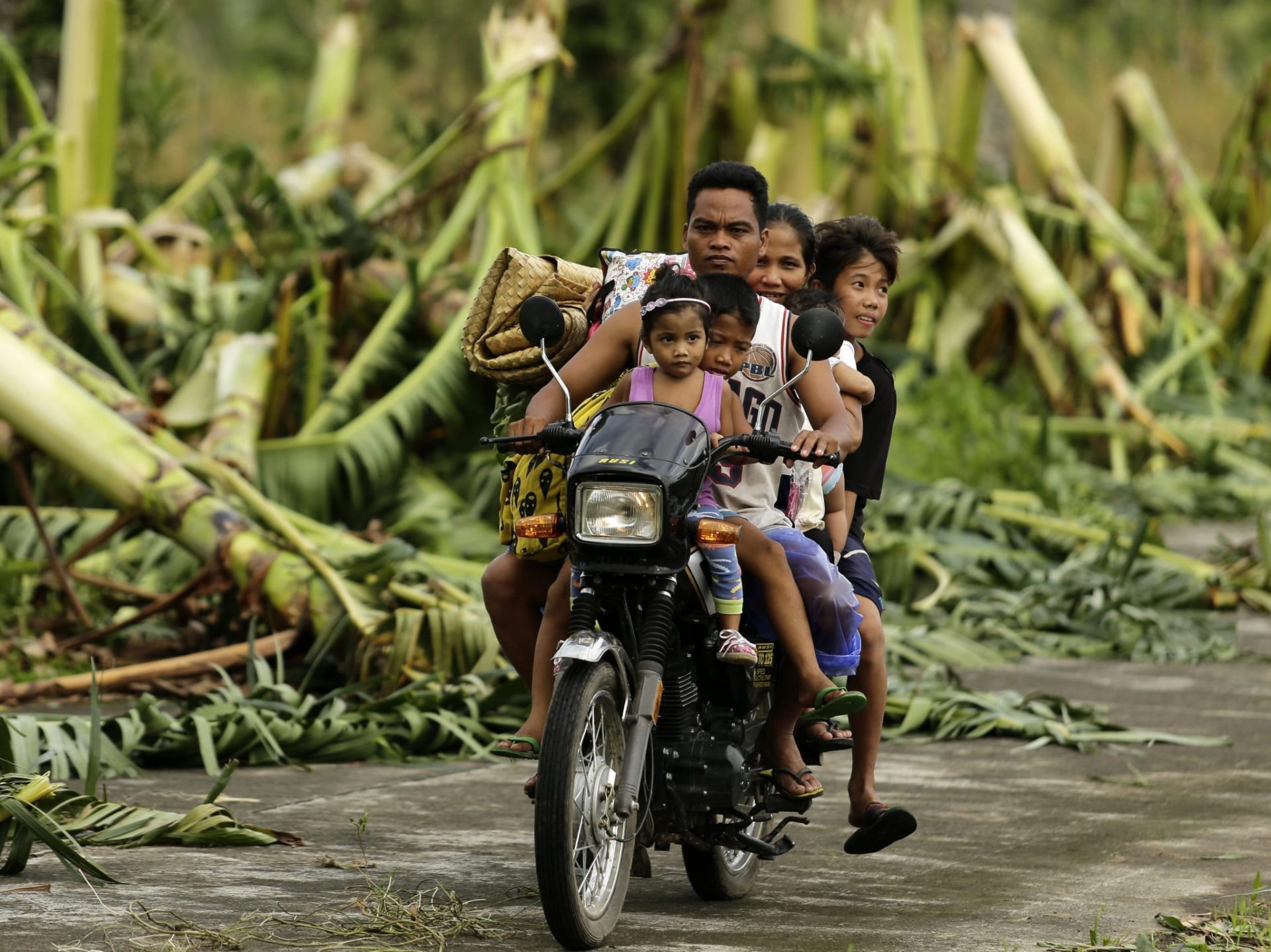 Una familia filipina a bordo de una motocicleta deja su hogar.