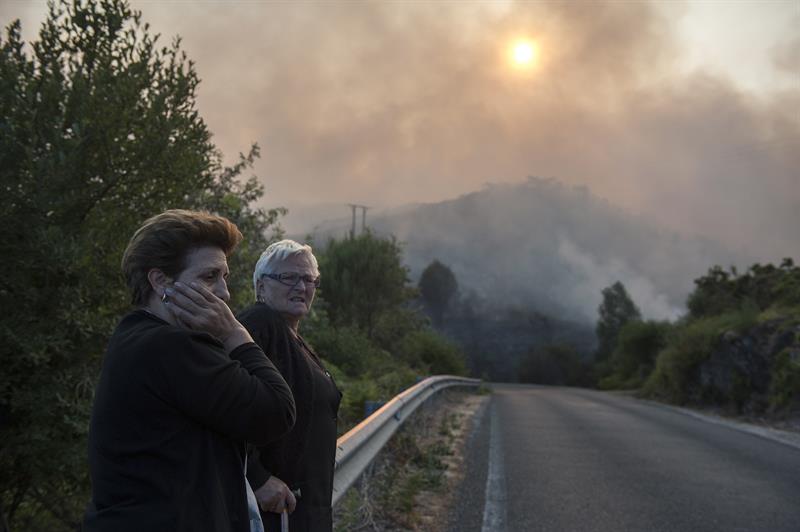 Dos mujeres muestran su desolación ante el incendio que afecta a la parroquia de Nieva en avión (Ourense). 