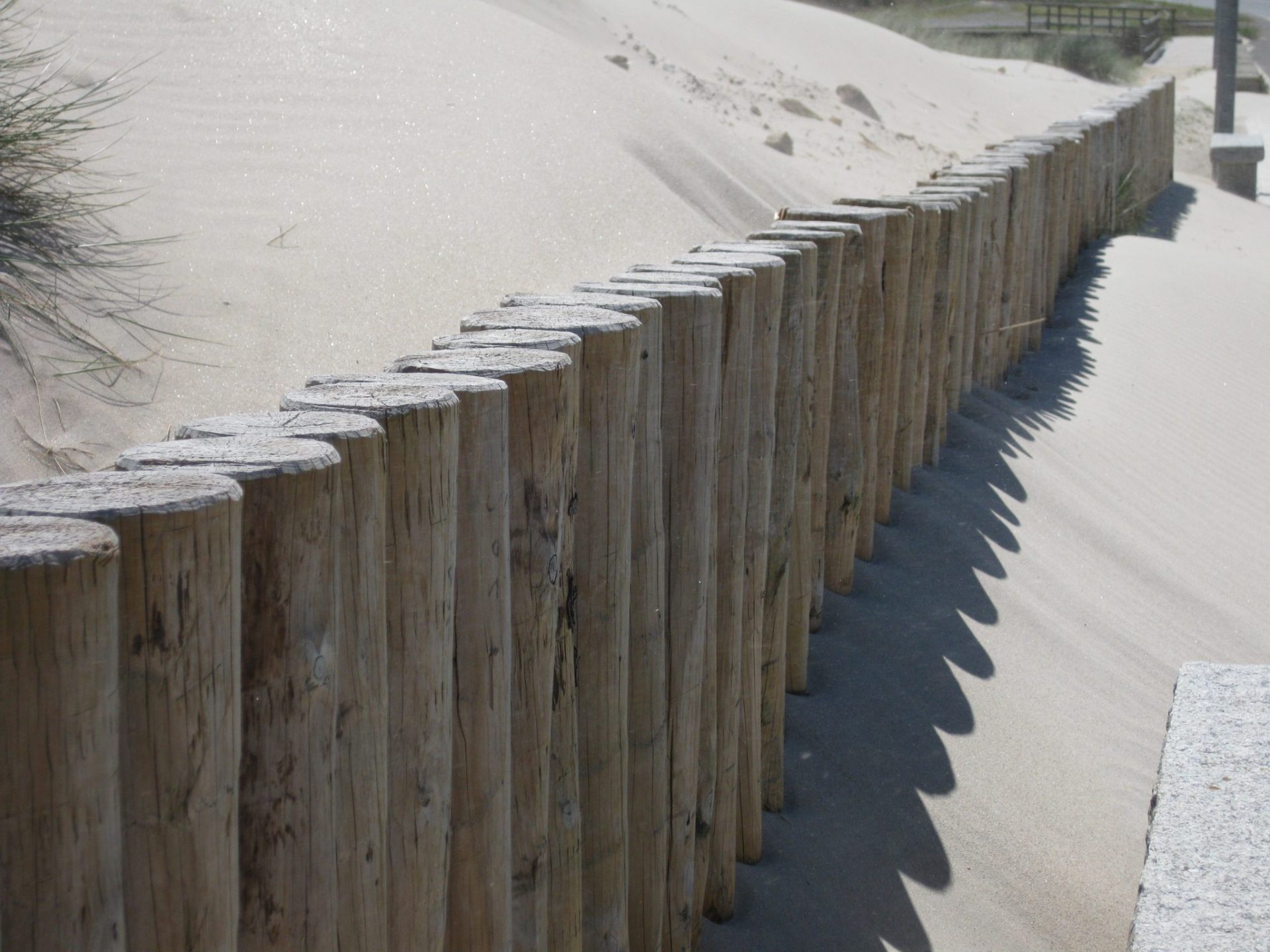 barrera de madera para parar el avance de la arena en una playa de Muxía