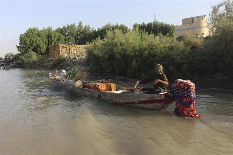 Iraquíes navegan en bote por un río en la zona de los "ahwar" (humedales) en Amara (Irak).
