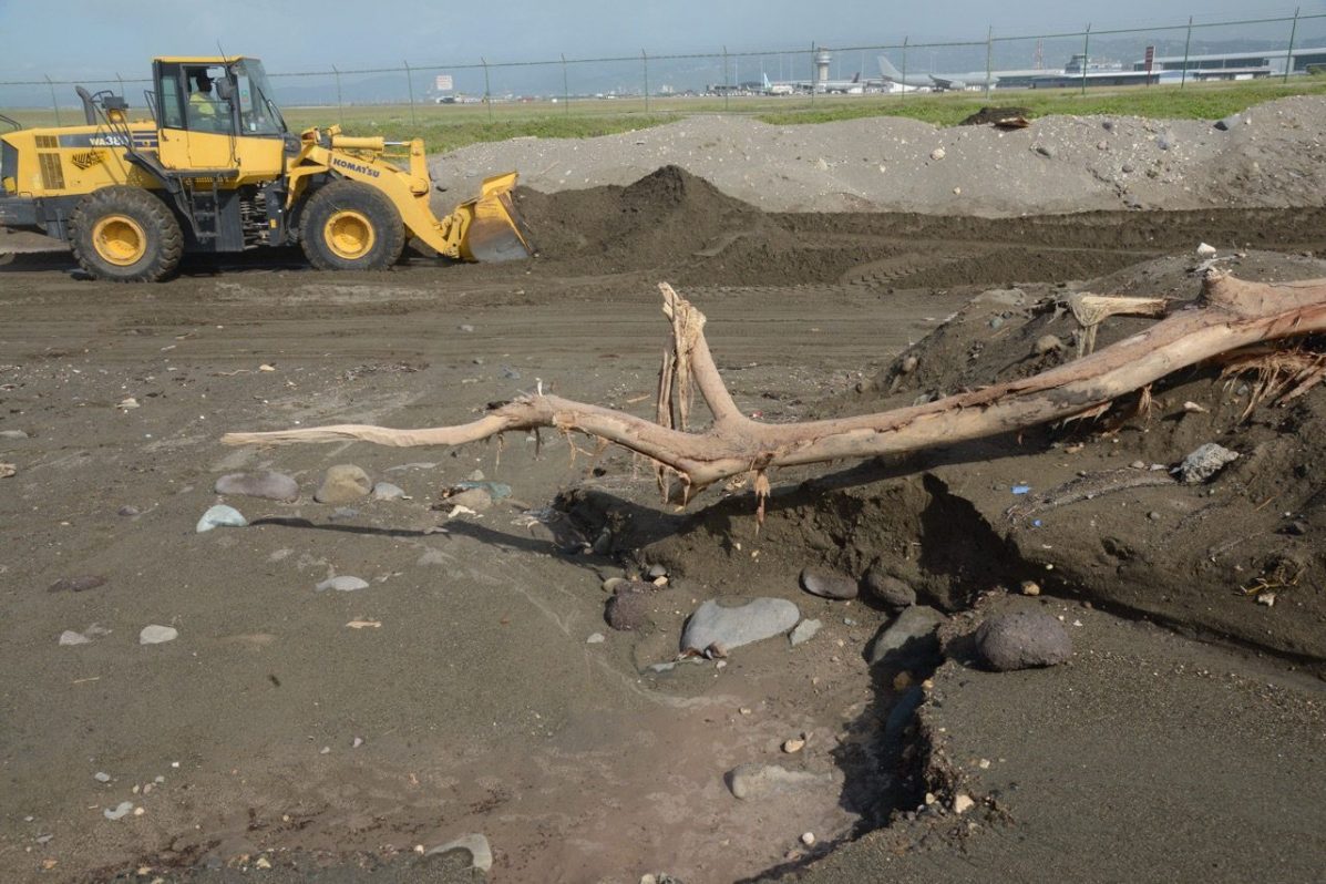 Una excavadora retira arena de una vía después de fuertes lluvias debido a al huracán Matthew