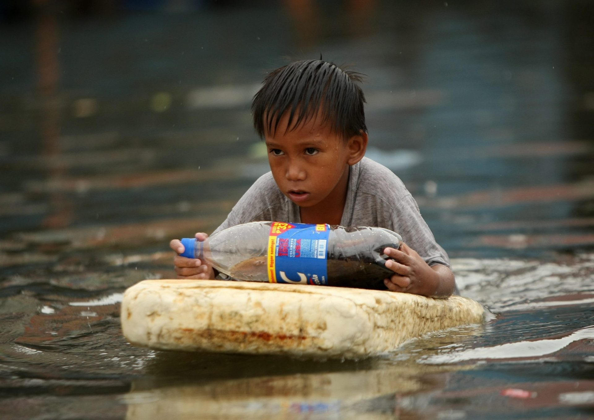 Un niño en una calle inundada tras el paso de un tifón en Manila (Filipinas).