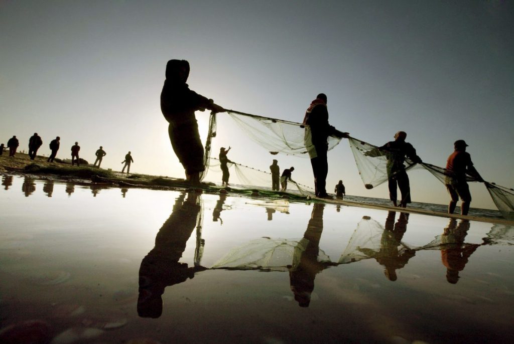 Pescadores tiran de una red de pesca en la playa de Ichinomiya (Japón).