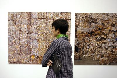Una joven observa una de las fotografías que forman parte de la exposición "Revolviendo en la basura. Residuos y reciclaje en el arte actual", que se expuso en el Centro de Arte y Naturaleza (CDAN) de Huesca en febrero de 2010.