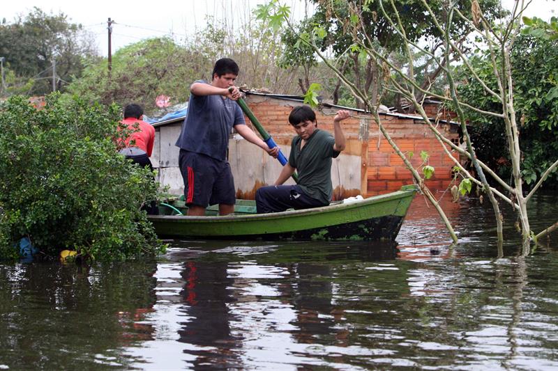 ASUNCIÓN (PARAGUAY), 08/07/2014.- Un grupo de personas rescatan un cerdo en un barrio inundado hoy, martes 8 de julio de 2014, en Asunción (Paraguay). El río Paraguay paró hoy de subir a su paso por Asunción por primera vez desde finales de mayo, según la Dirección de Meteorología e Hidrología, que prevé que se estabilice en su nivel actual, de 7,35 metros, y comience una bajada lenta esta misma semana. La crecida de los ríos por las lluvias de los últimos meses ha desplazado a 240.125 personas en todo Paraguay, 80.060 de ellas en la capital Asunción, según la Secretaría de Emergencia Nacional (SEN). EFE/Andrés Cristaldo