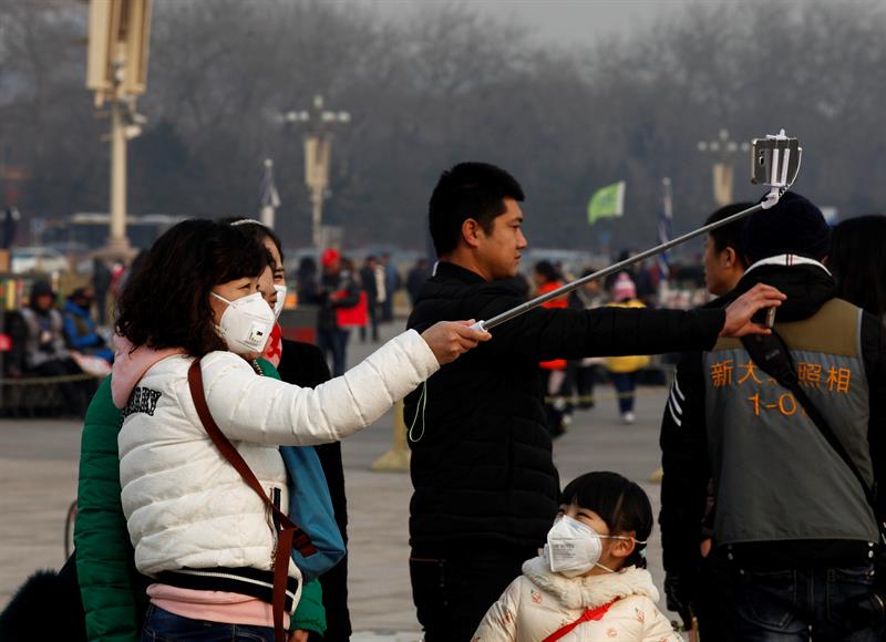 Turistas se hacen un selfi con las mascarillas en la plaza Tiananmen
