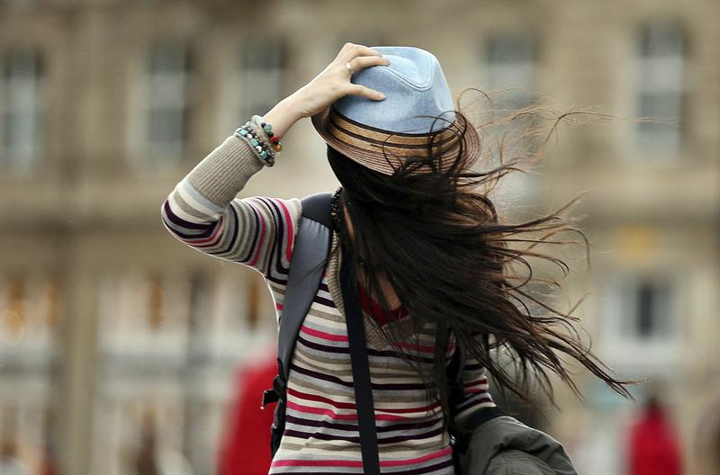 Una chica se sujeta el sombrero mientras lucha contra el viento en Colonia (Alemania), este lunes 28 de octubre de 2013.