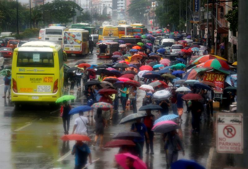 MANILA (FILIPINAS) 08/07/2016.- Varios filipinos caminan por la calle a la espera de que se reestablezca el transporte público en Pásay, sur de Manila, Filipinas, hoy, 8 de julio de 2016. El tifón Nepartak perdió intensidad al entrar en la isla y el norte de Taiwán ya ha restablecido esta mañana el transporte público y los vuelos en los aeropuertos. Sin embargo, el sur y este de la isla, no se ha salvado de las lluvias torrenciales y de los fuertes vientos. El tifón Nepartak ha causado dos muertos y 70 heridos en la isla, graves pérdidas materiales por daños en infraestructura, edificios y explotaciones agrícolas.