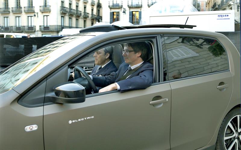 Puigdemont (d), con el presidente de Seat, Luca de Meo (i), conduce hasta la Fira Gran Via, un Seat e-Mii, un coche eléctrico desarrollado en la planta de Martorell (Barcelona).