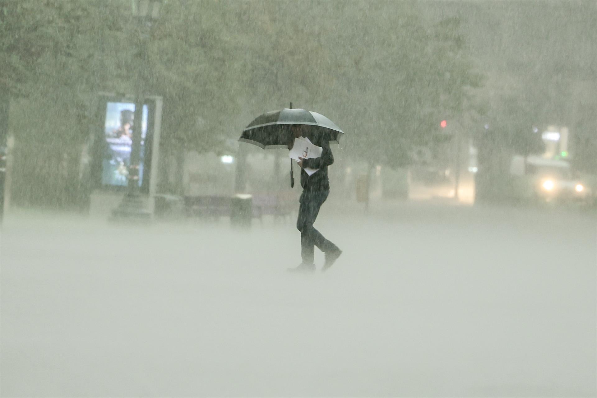 -FOTODELDIA- VALENCIA, 11/11/2022.- Un hombre camina bajo la intensa lluvia este viernes en Valencia. La tormenta asociada a la DANA está provocando lluvias de intensidad muy fuerte en algunas zonas del oeste y sur del área metropolitana. EFE/ Biel Aliño