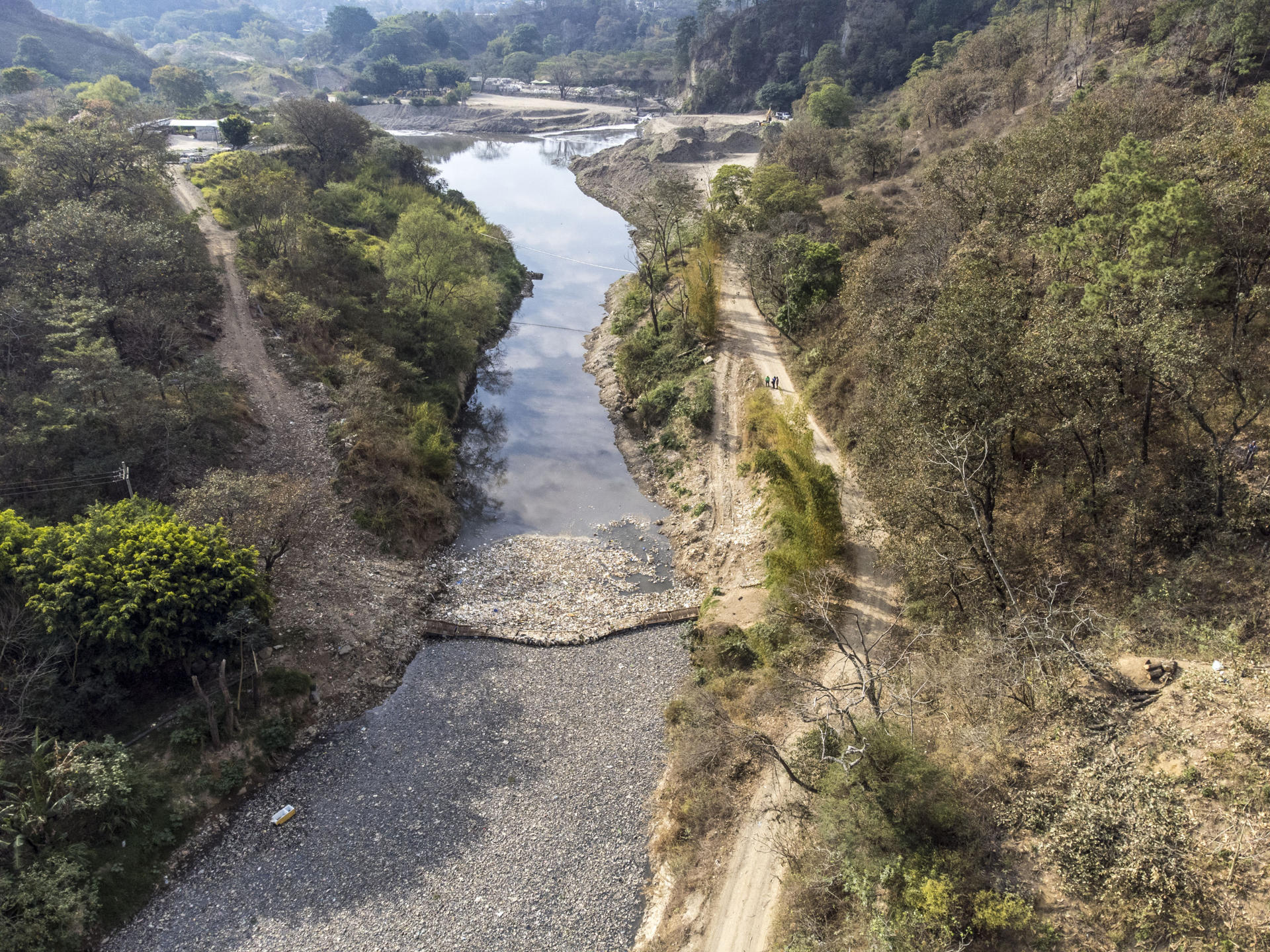 ACOMPAÑA CRÓNICA AME3154. CHINAUTLA (GUATEMALA), 17/03/2023.- Fotografía con drone del 10 de marzo 2023, de una biobarda que intenta contener cientos de toneladas de basura que atraviesan el río Las Vacas, provenientes de la Ciudad de Guatemala, en Chinautla (Guatemala). Guatemala tiene el doble de disponibilidad de agua que el promedio mundial, pero el 90 % de sus fuentes están contaminadas y millones de personas sufren un calvario diariamente para obtenerla, debido a décadas de una deficiente administración estatal. EFE/Esteban Biba