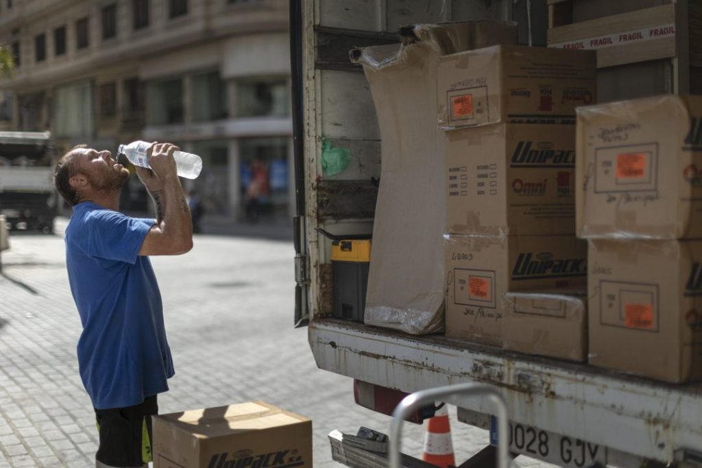 Imagen de archivo de un trabajador de una empresa de mudanzas refrescándose para combatir el calor. EFE/Biel Aliño