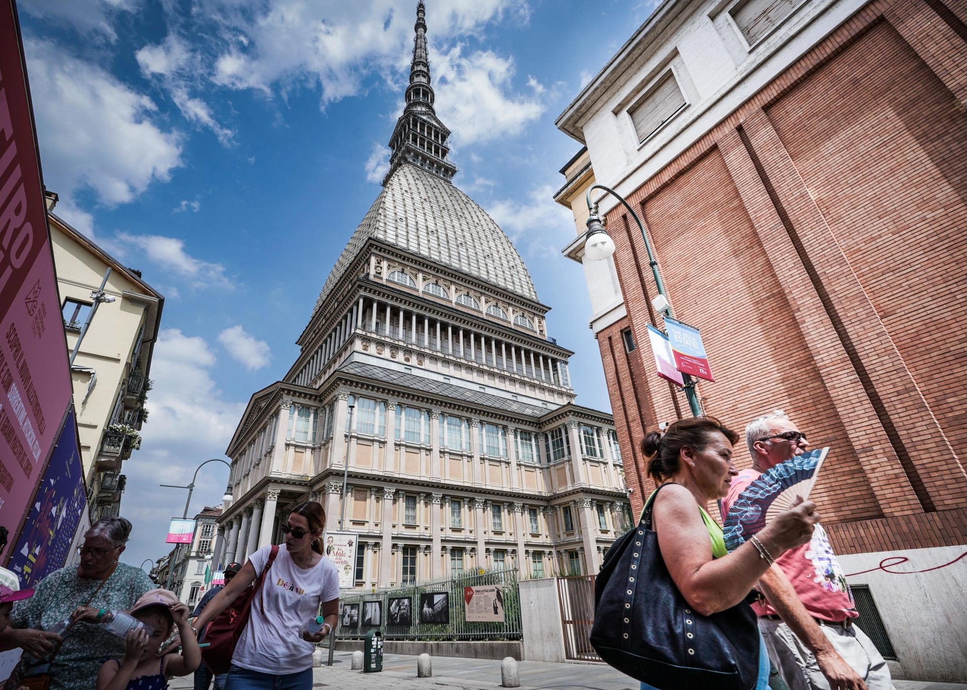 Turin (Italy), 19/07/2023.- Tourists walk near the Mole Antonelliana landmark building amid a heat wave in Turin, northern Italy, 19 July 2023. Major Italian cities are on red alert due to the country's third heatwave of the summer. The country's health ministry on 19 July is activating a helpline for people to seek assistance and advice about coping with the heat as the peninsula is hit with record-high temperatures. (Italia) EFE/EPA/TINO ROMANO