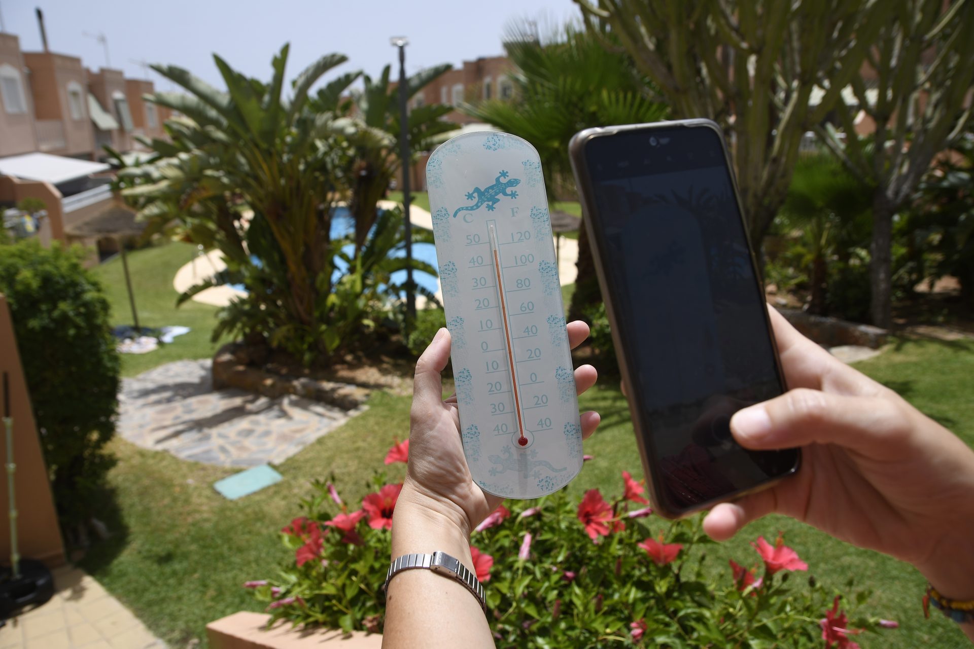 GRAFAND3745. ROQUETAS DE MAR (ALMERÍA), 12/07/2023.-Una persona fotografía un termómetro que se encuentra en el exterior de un recinto con piscina en Roquetas de Mar (Almería), este miércoles cuando la ola de calor ha obligado activar el aviso rojo por temperaturas extremas en varias comarcas almerienses y en Málaga. EFE / Carlos Barba