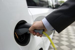 Un hombre conecta el cargador al coche eléctrico, en una fotografía de archivo. EFE/Sebastian kahnert