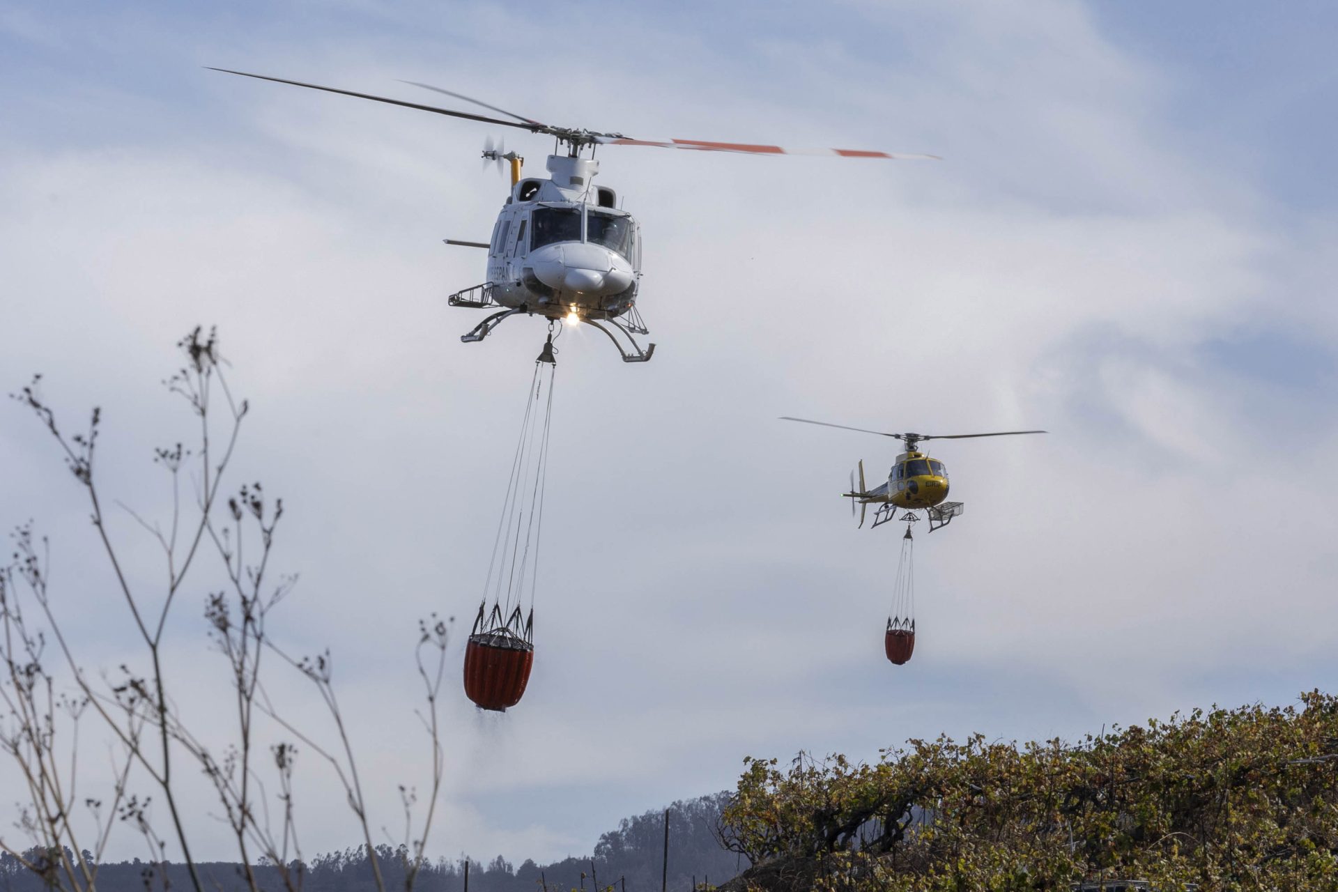 Imagen de dos helicópteros cargando agua para refrescar la zona del incendio forestal en el municipio tinerfeño de Santa Úrsula, el pasado sábado. EFE/Miguel Barreto