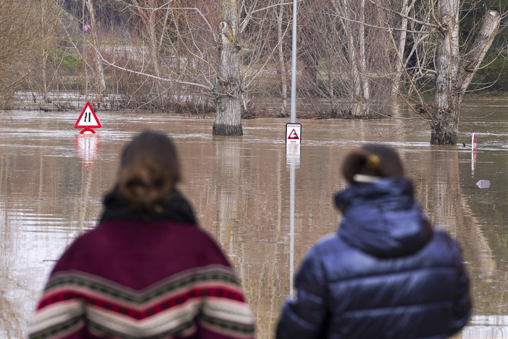 VIANA DE CEGA (VALLADOLID), 21/01/2024.- Dos vecinas afectadas observa la crecida del rio Cega a su paso por la localidad vallisoletana de Viana de Cega que ha obligado a varios vecinos abandonar sus casas esta madrugada. EFE/Nacho Gallego