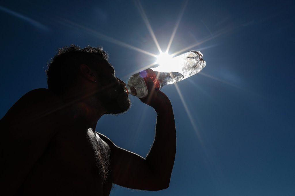 AME932. RÍO DE JANEIRO (BRASIL), 19/09/2023.- Un hombre bebe agua durante el descanso de una actividad física hoy en la playa de Copacabana, en Río de Janeiro (Brasil). Brasil se enfrenta a una ola de calor en nueve estados del país que durará entre tres y cinco días y llevará las temperaturas a ser cinco grados superiores a la media histórica, alertó este martes el Instituto Nacional de Meteorología. EFE/André Coelho