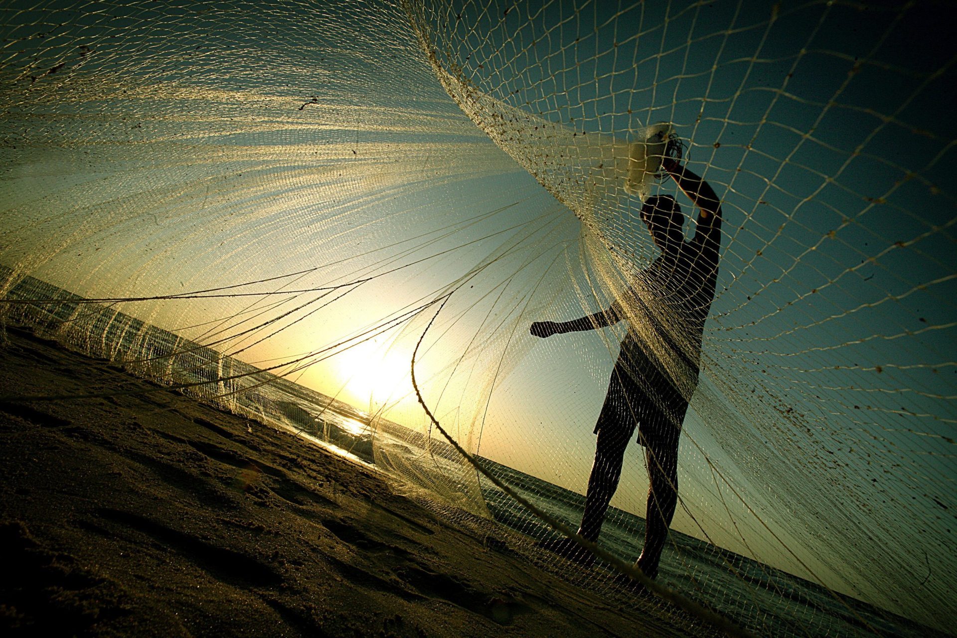 AA101 CIUDAD DE GAZA (FRANJA DE GAZA), 15.09.09.- Un pescador palestino lanza sus redes en la playa de Ciudad de Gaza, en la mañana de hoy martes 15 de septiembre. Los pescadores palestinos acuden a la playa todas las mañanas, aunque los soldados de la Marina israelí no les permiten adentrarse en el mar. EFE/Ali Ali