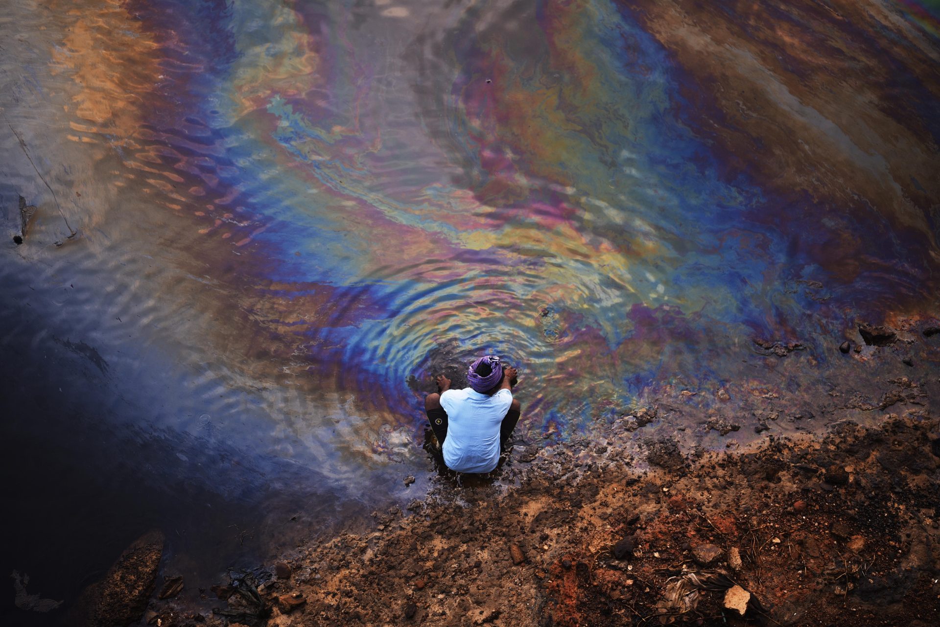 Chennai (India), 11/12/2023.- An Indian fisherman washes his hands in the waters of Ennore Creek covered with an oil spill after Cyclone Michaung, in Chennai, India, 11 December 2023. According to a survey by the Indian Coast Guard, the oil spill reported in the floodwaters in the Ennore-Manali area in North Chennai after Cyclone Michaung has now reached the sea and spreads over an area of 20 sq km from the mouth of the Kosasthalaiyar River to Kasimedu harbor. The Tail Nadu government constituted a 20-member State of Oil Spill Crisis Management Group to mitigate the oil in the Ennore-Manali region. EFE/EPA/IDREES MOHAMMED
