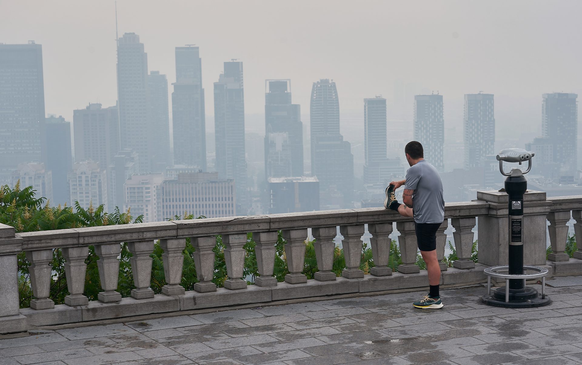 Fotografía de archivo que muestra a un hombre en un mirador en la ciudad de Montreal, envuelta en una niebla tóxica producto de una serie de incendios forestales que afectaron el año pasado a Canadá. EFE/ANDRE PICHETTE