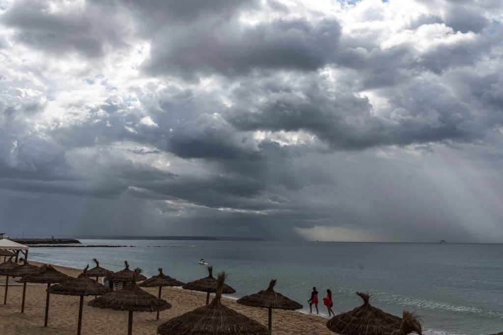GRAF3350. PALMA DE MALLORCA, 02/10/2019.- Una pareja camina bajo la lluvia en la Playa de Can Pere Antoni , en Palma. La previsión meteorológica en Menorca y Mallorca es nuboso con chubascos ocasionales y dispersos que podrían ser localmente fuertes y con tormenta abriéndose claros durante la tarde de oeste a este; en las Pitiusas, predominio de cielo poco nuboso con baja probabilidad de alguna precipitación ocasional. Temperaturas en descenso, localmente notable las diurnas. Vientos de componente norte con intervalos fuertes en Menorca.- EFE/CATI CLADERA-EFE/CATI CLADERA