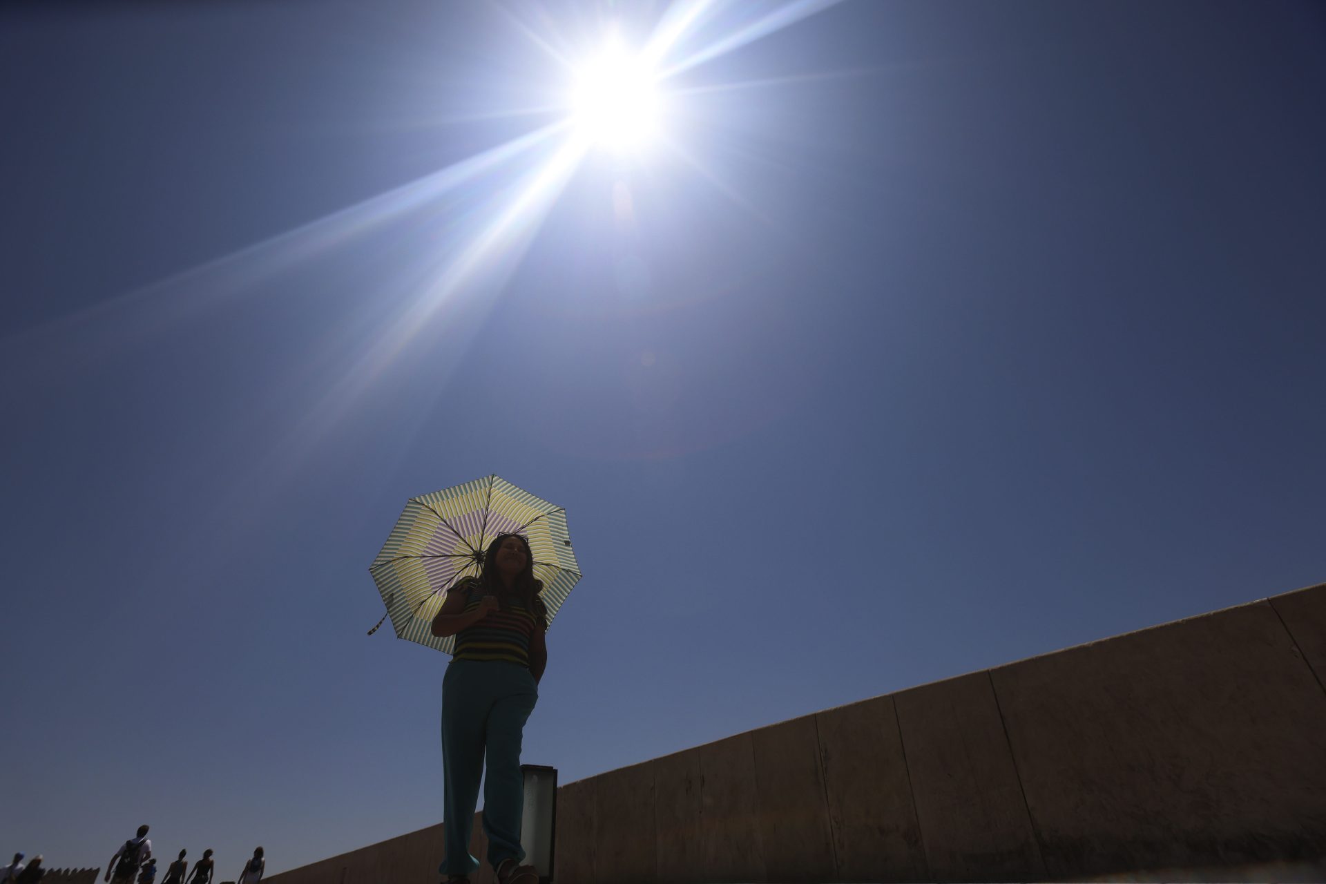 GRAFAND2849. CÓRDOBA, 06/08/2024.- Una mujer se protege del sol con una sombrilla mientras camina por el centro de la capital cordobesa, este martes cuando la Agencia Estatal de Meteorología (AEMET) alerta de que habrá temperaturas significativamente altas en el interior, con 41 grados en Córdoba, 39 en Granada y 38 en Jaén. EFE/Salas