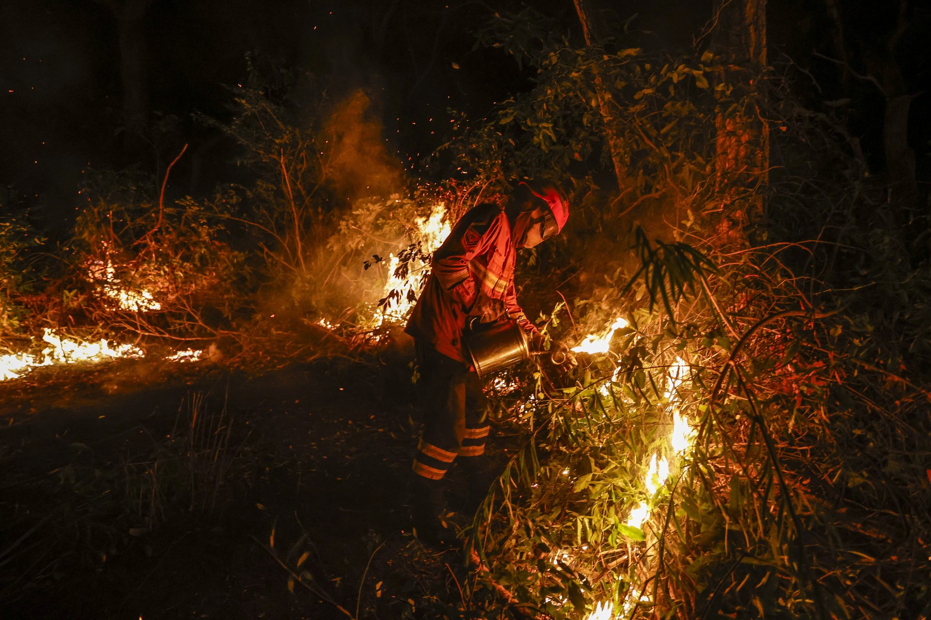 AME8460. CORUMBÁ (BRASIL), 30/06/2024.- Un bombero trabaja en la extinción de un incendio este domingo en la ciudad de Corumbá (Brasil). Los bomberos que actúan contra los incendios en el Pantanal, un vasto humedal compartido por Brasil, Bolivia y Paraguay, consideraron este domingo que las llamas han comenzado a retroceder, pero admitirán que todavía no pueden controlarlas por completo. EFE/ Sebastiao Moreira
