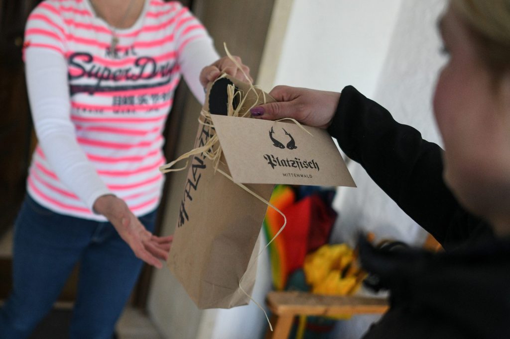 Mittenwald (Germany), 08/04/2020.- Manuela Merk delivers smoked fish from her small fish shop Platzfisch to a customers doorstep in Mittenwald, Germany, 08 April 2020. Due to the ongoing pandemic of the COVID-19 disease caused by the SARS-CoV-2 coronavirus, owner Dominik Blees is faced with fewer orders from hotels and restaurants and holiday resorts, so she delivers to local end customers and sells directly from his small shop. (Alemania) EFE/EPA/PHILIPP GUELLAND ATTENTION: This Image is part of a PHOTO SET[ATTENTION: This Image is part of a PHOTO SET]