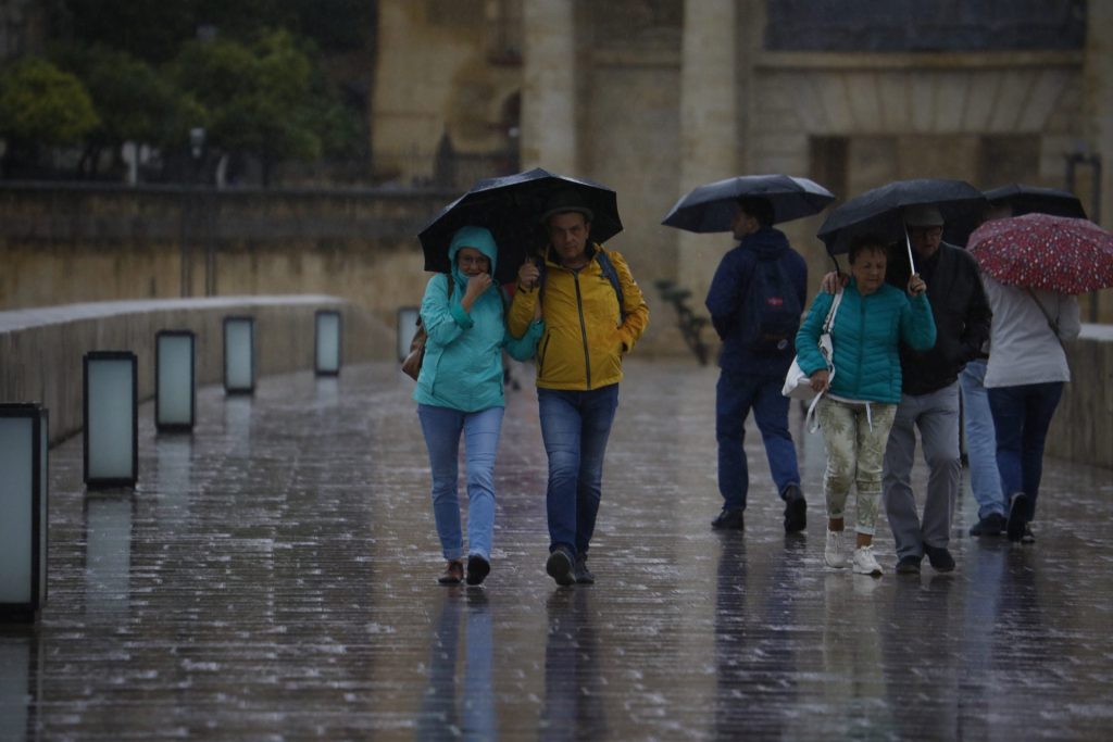 GRAFAND4218. CÓRDOBA, 29/10/2024.- Unos turistas se cubren con paraguas de la lluvia en Córdoba. El Centro de Coordinación de Emergencias 112 ha gestionado 604 incidencias por el temporal que azota desde anoche Andalucía, sin que hasta el momento haya constancia de personas heridas, según el último balance de este organismo, que recuerda que se mantiene activo el Plan de Emergencia ante el Riesgo de Inundaciones (PERI) en fase de emergencia. EFE/Salas
