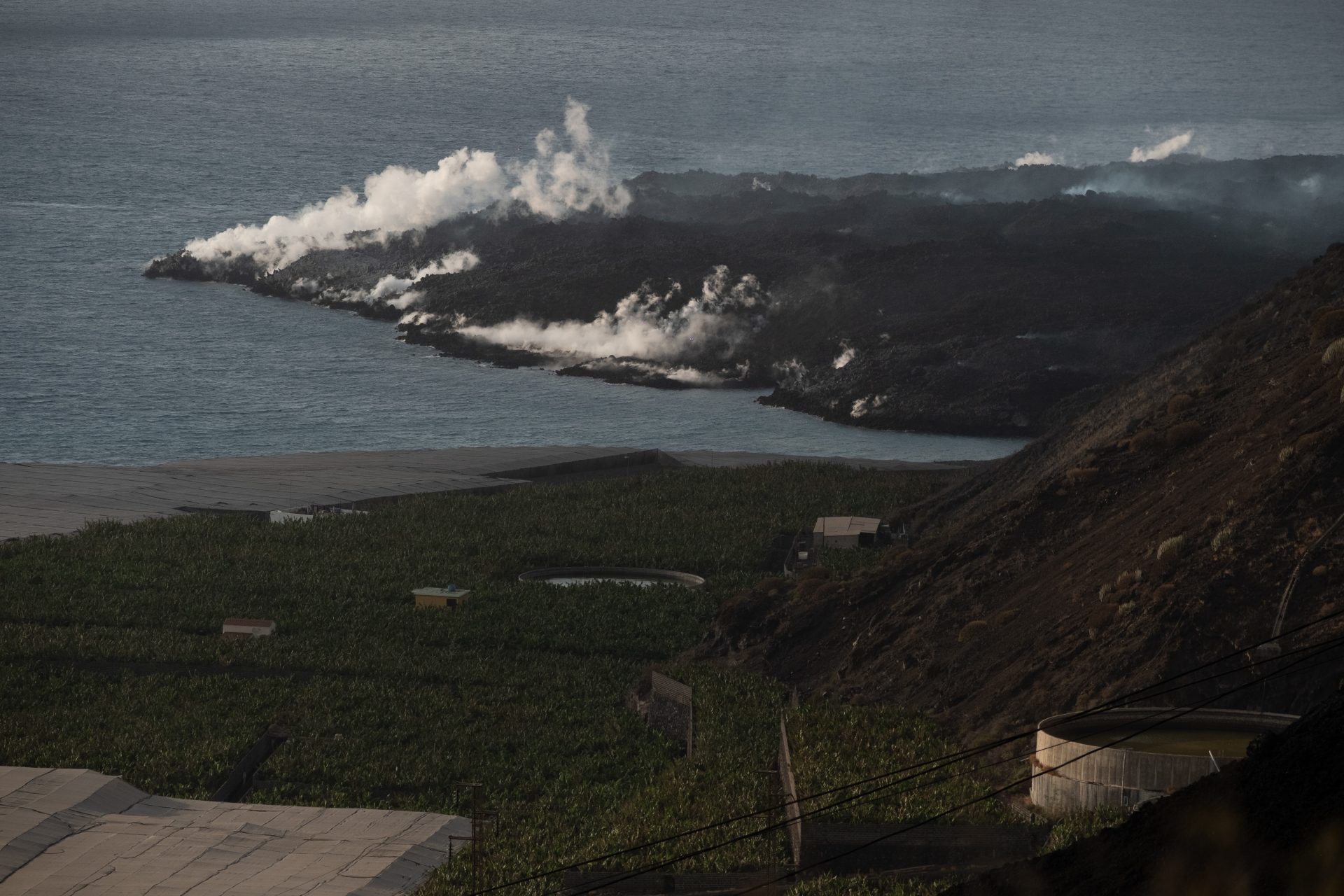 GRAFCAN4168. PUERTO NAOS (LA PALMA) (ESPAÑA), 04/10/2021.- Las coladas de lava que no han cesado de descender desde el volcán de La Palma están formando una fajana (o delta) de terrenos volcánicos ganados al mar en la costa de Tazacorte, como muestra esta imagen tomada este lunes desde Puerto Naos, en la zona evacuada por precaución. EFE/Carlos de Saá