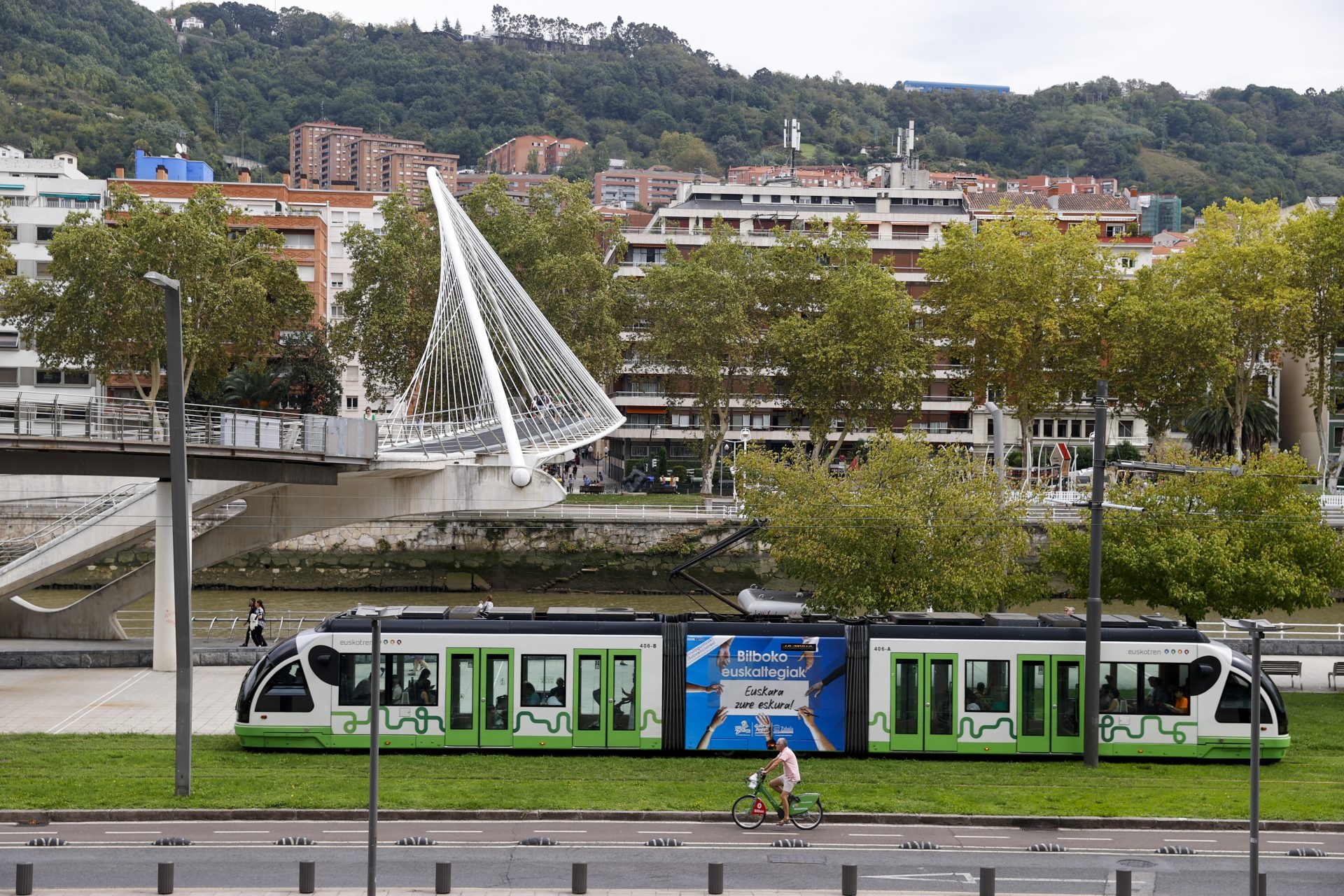 GRAFCAV3195. BILBAO, 15/09/2023.-Un tranvía que le alimenta de energía eléctrica, circula este viernes junto a la ria de Bilbao. ¡Combina y muévete!' es el lema empleado este año para apoyar la Semana Europea de la Movilidad (SEM) que se celebra oficialmente desde mañana sábado hasta el próximo viernes 22 con la eficiencia energética como principal objetivo para la edición de este año. EFE/Luis Tejido
