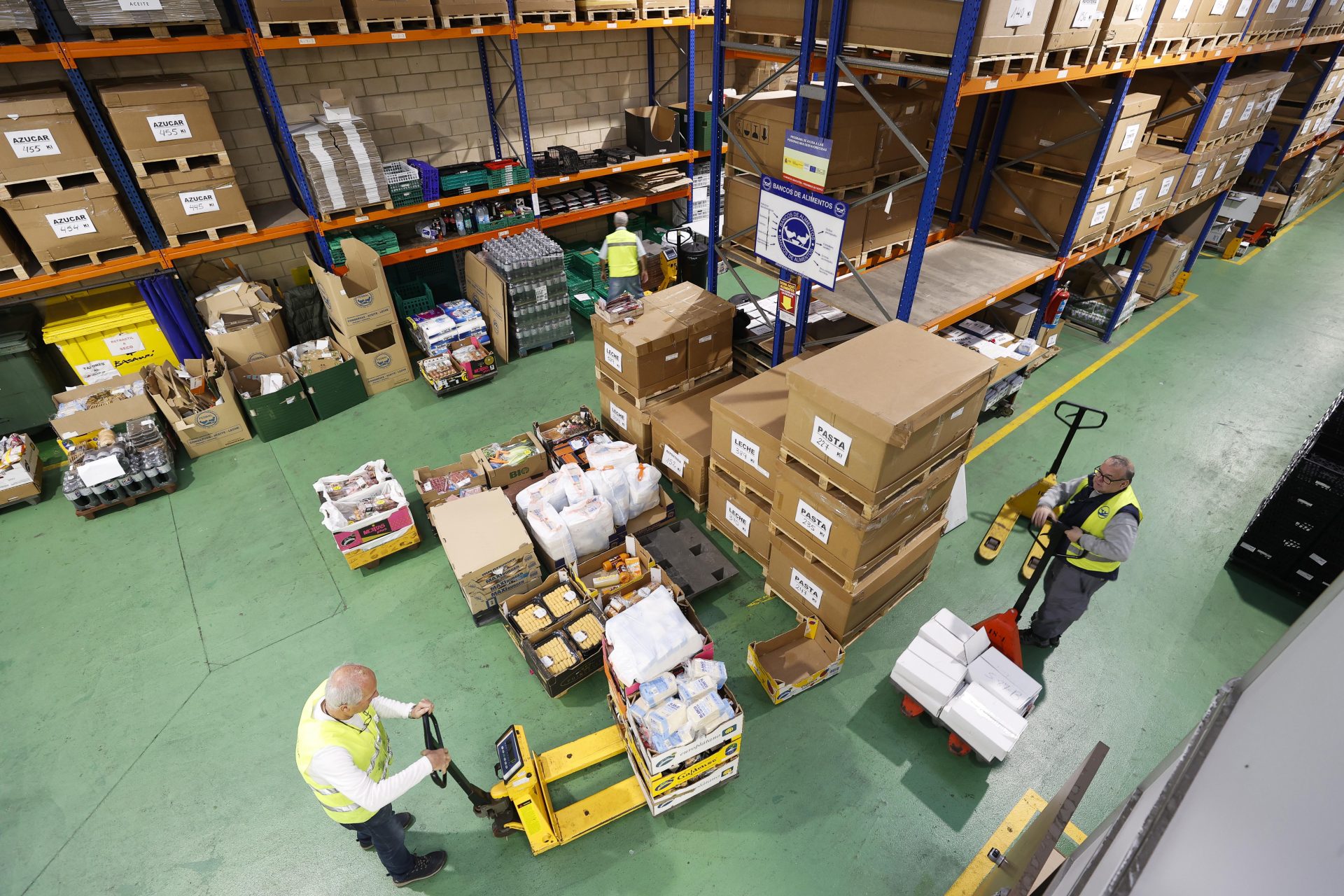 GRAFCAV3356 BASAURI (BIZKAIA), 16/12/2022.- Un grupo de voluntarios ordena cajas de comida en el Banco de Alimentos de Bizkaia, que ha comenzado este viernes el reparto de cestas solidarias de alimentos a 12.000 familias vizcaínas con la participación de los hermanos Iñaki y Nico Williams y el presidente de BBK, Xabier Sagredo. EFE/Miguel Toña