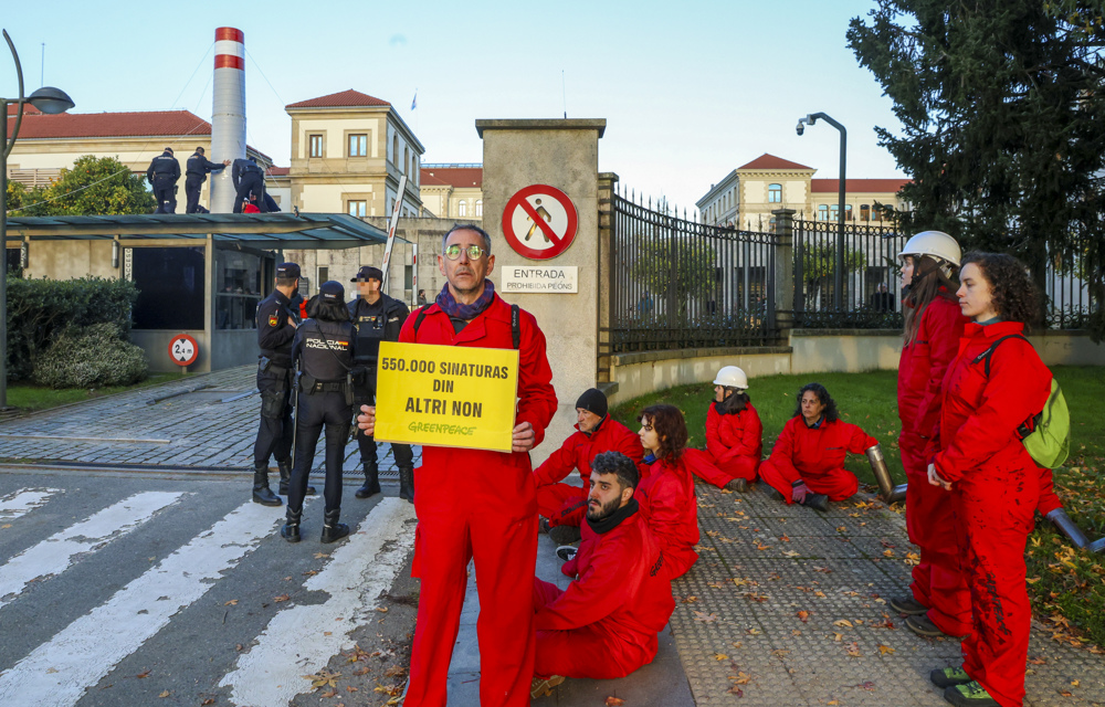 SANTIAGO DE COMPOSTELA, 12/12/2024.-Policías retiran una chimenea colocada por activistas de Greenpeace en uno de los accesos al complejo administrativo de San Caetano, sede de la Xunta, acompañada de pancartas con el lema 'Altri Non', para exigir la paralización del proyecto de celulosa "en el corazón de Galicia". EFE/ Xoán Rey