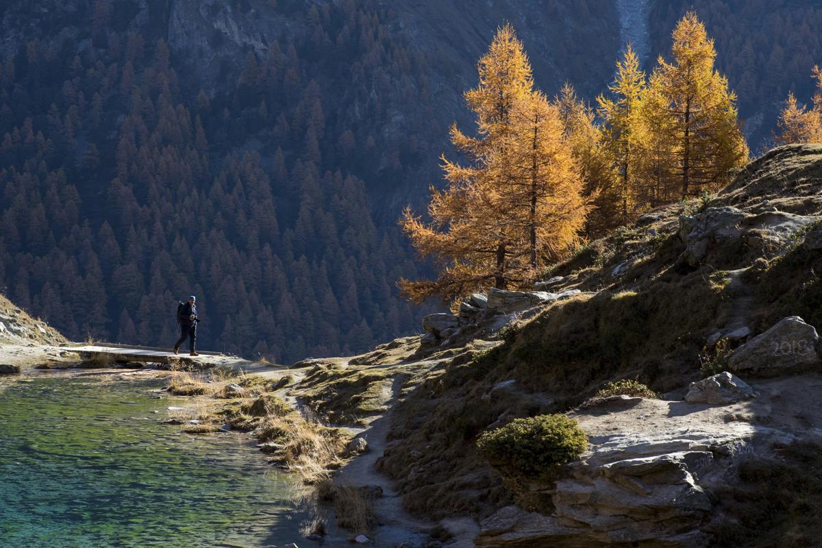 Un hombre camina cerca del Lago Azul de Arolla (2090m) en un día de otoño, cerca de Arolla, en Valais, Suiza, en una imagen de archivo. EFE/ ANTHONY ANEX