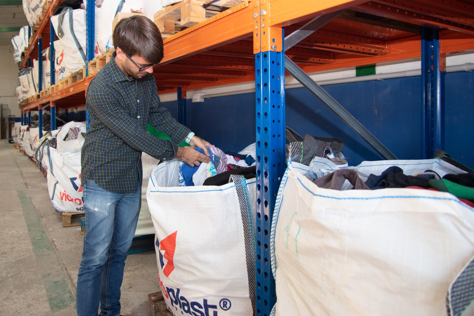 Una persona inspecciona el contenido de una bolsa con residuos textiles para reciclar, en una imagen de archivo. EFE/ Javier G. Paradelo