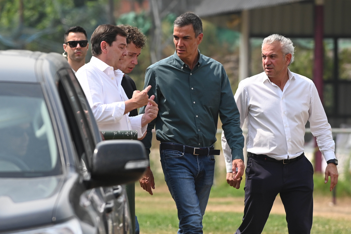 Imagen del presidente del Gobierno, Pedro Sánchez (c), junto al de la Junta de Castilla y León, Alfonso Fernández Mañueco (i), a su llegada a Caboalles (León) este domingo para seguir la última hora del incendio de Orallo (León). EFE/ J.Casares