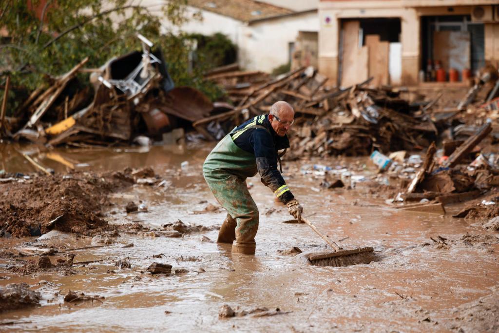 GRAFCVA3935. PAIPORTA (VALENCIA), 14/11/2024.- Un bombero participa en las labores de limpieza en las calles de Paiporta, Valencia, este jueves. AEMET ha bajado el aviso de fenómenos meteorológicos adversos de rojo a naranja en la zona mas afectada por la DANA de hace dieciséis día. EFE/Biel Aliño
