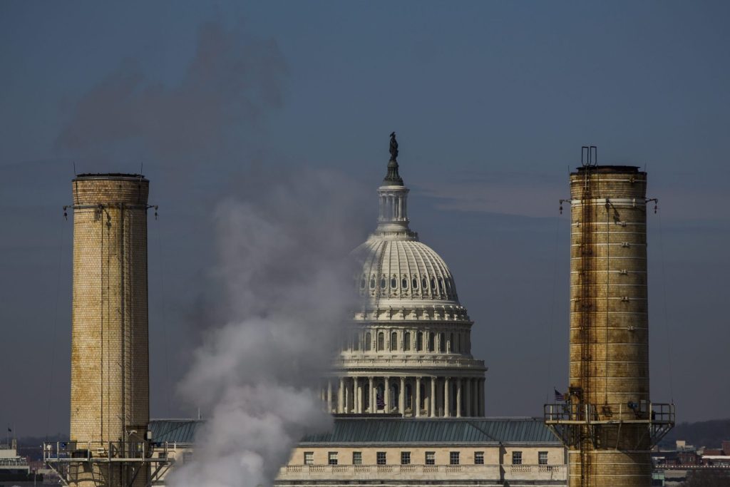 JL04. WASHINGTON (DC, EE.UU.), Vista del domo del Capitolio entre dos chimeneas de la Planta de Energía Capital, la única central eléctrica de carbón en la capital de Estados Unidos, en Washington hoy, lunes 10 de marzo de 2014. Senadores demócratas e independientes tienen programado una reunión en horas de la noche para hablar sobre el cambio climático. EFE/JIM LO SCALZO