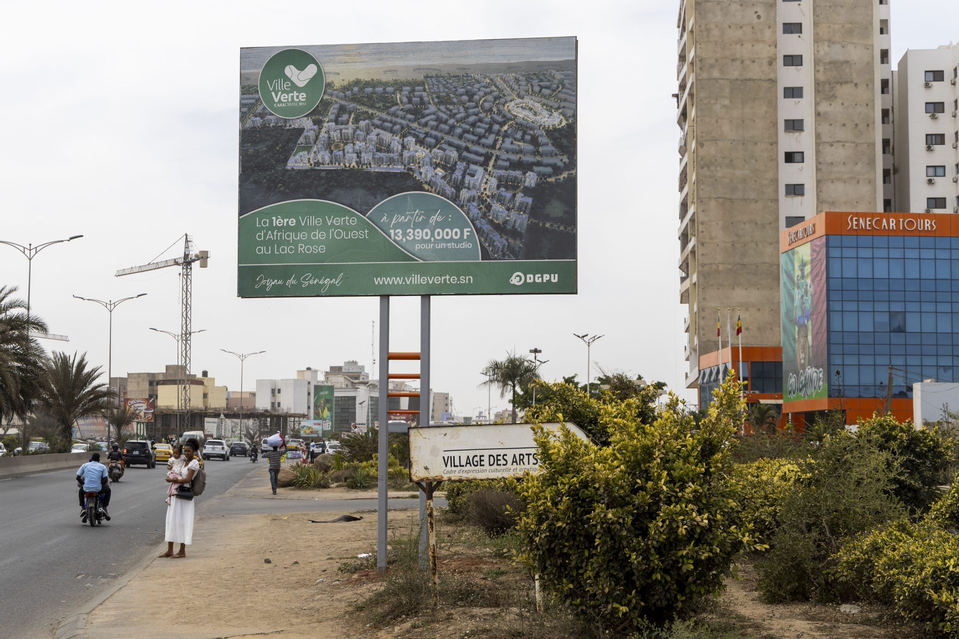 En las dunas coloreadas que bordean el famoso lago Rosa, gran atracción turística de Senegal a apenas 30 minutos de la capital, Dakar, se libra una batalla medioambiental por un proyecto inmobiliario que amenaza a ese paraje natural único. De un lado, el Gobierno senegalés y una multinacional egipcia promueven la construcción de una “ciudad verde”, moderna y ecológica, que albergaría 18.000 viviendas. En la imagen, vista de un cartel publicitario del proyecto inmobiliario conocido como Ville Verte (ciudad verde, en francés), que amenaza el famoso lago Rosa, gran atracción turística de Senegal a apenas 30 minutos de la capital, visto en Dakar, capital de Senegal. EFE/Eduardo S. Molano.
